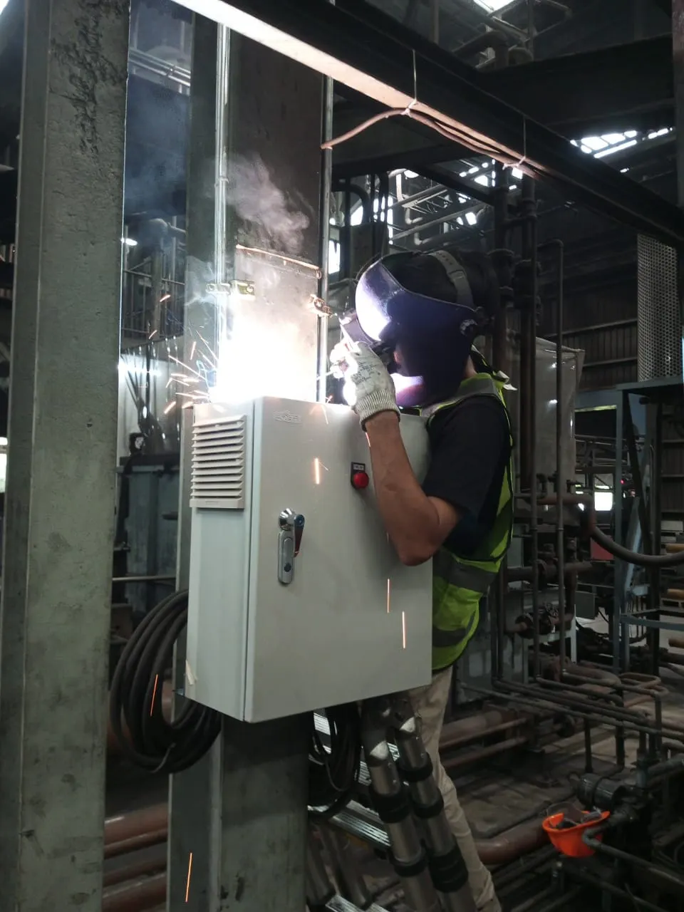 Teknisi Machvory memasang panel akuisisi data pada tiang di area produksi