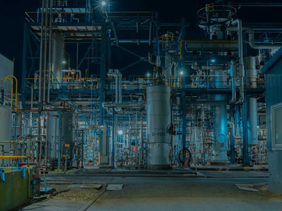 Instalasi industri proses dengan jaringan pipa dan tangki pada malam hari