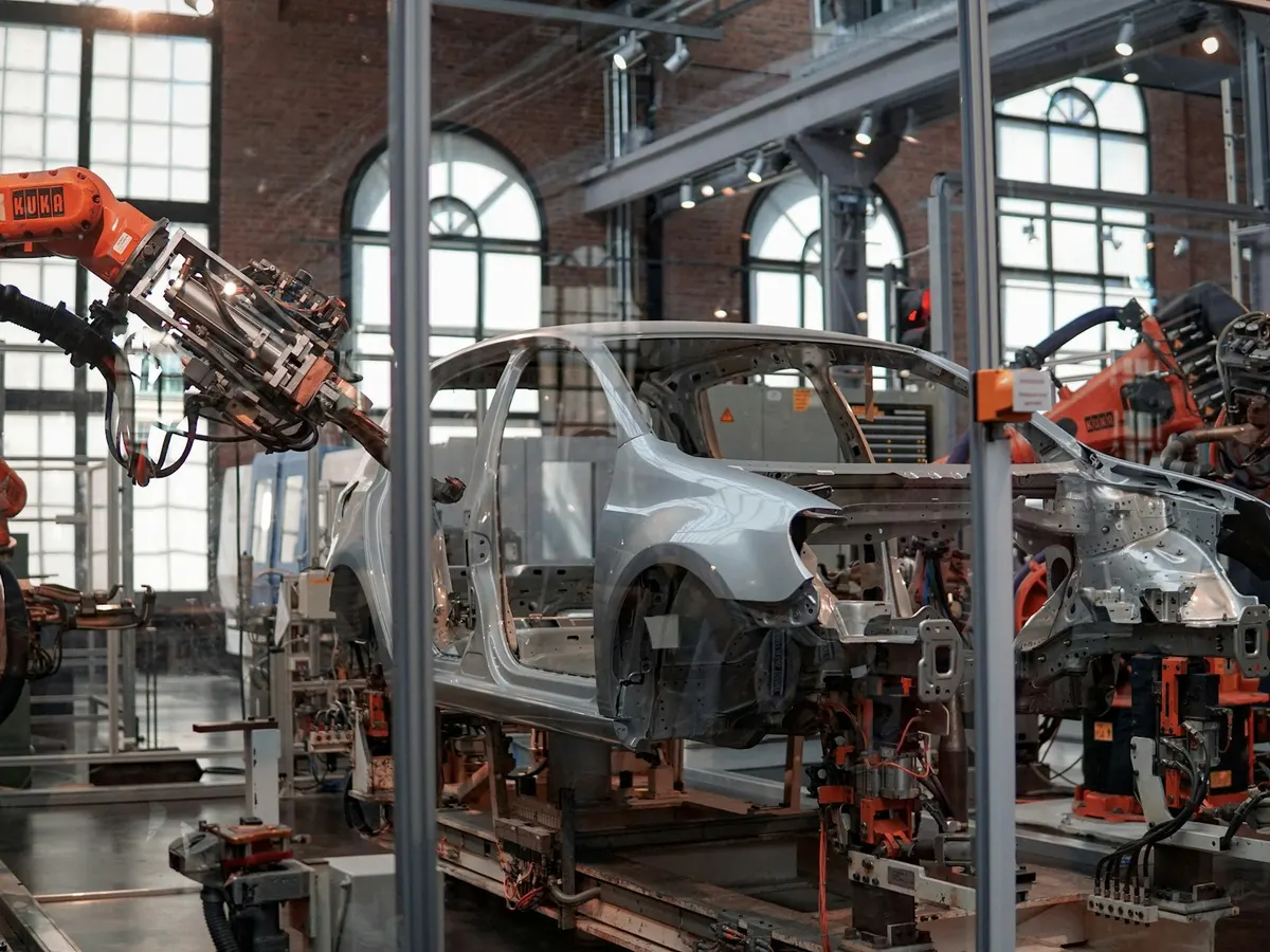 Bodi mobil di lini perakitan otomotif yang dikerjakan lengan robot